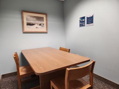 Study room with table and three chairs and artwork on the wall