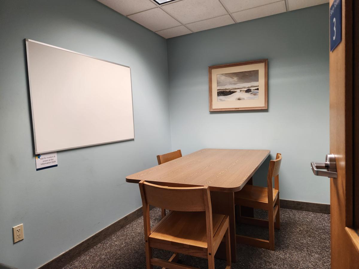 Study room with table and three chairs and artwork on the wall