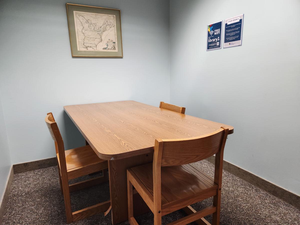 Study room with table and three chairs and artwork on the wall